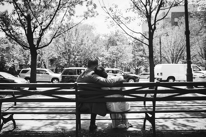 bride and groom hugging on bench