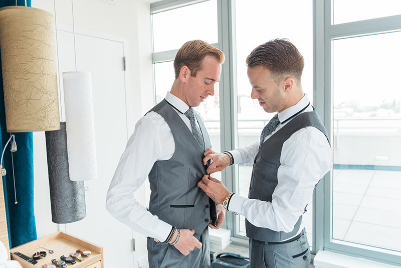 grooms helping each other