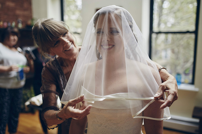 mother putting veil on bride