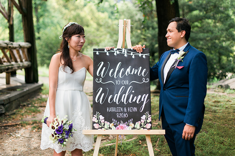 bride and groom with the wedding sign