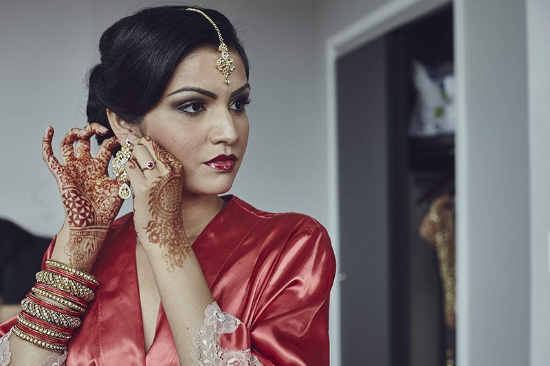 indian bride putting her earrings on