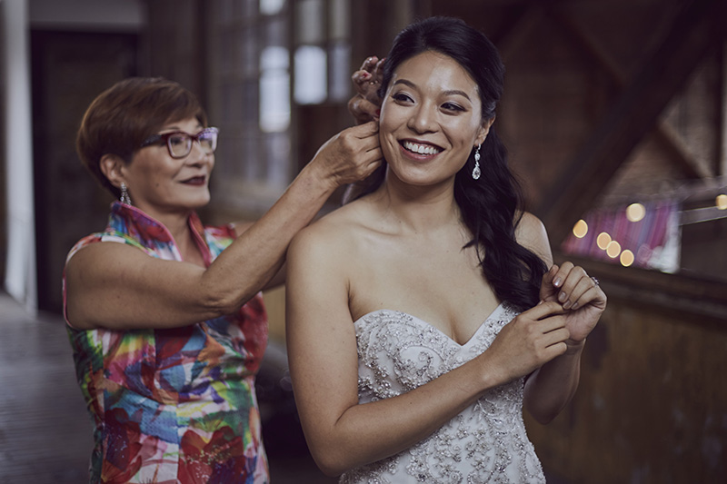 mother putting bride earrings on