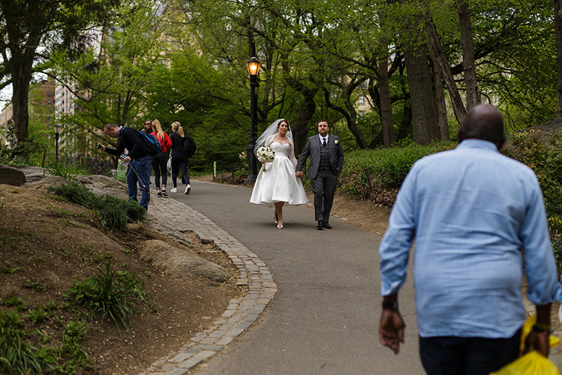 bride and groom walking in central park