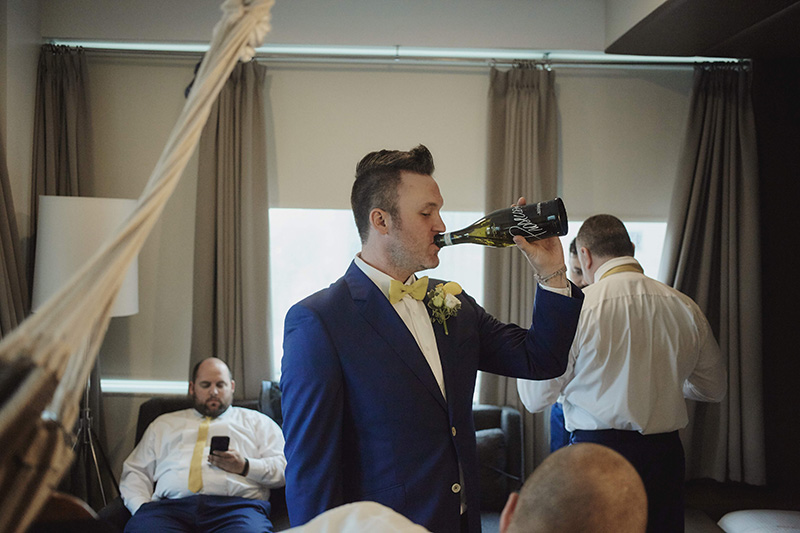 groom drinking champaign from the bottle