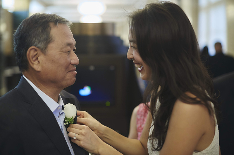 bride putting boutonniere on father  