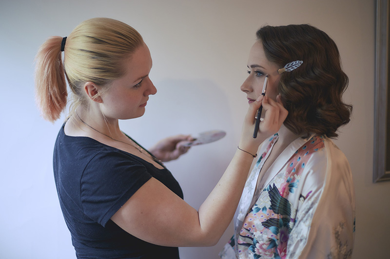 bride putting the make up on