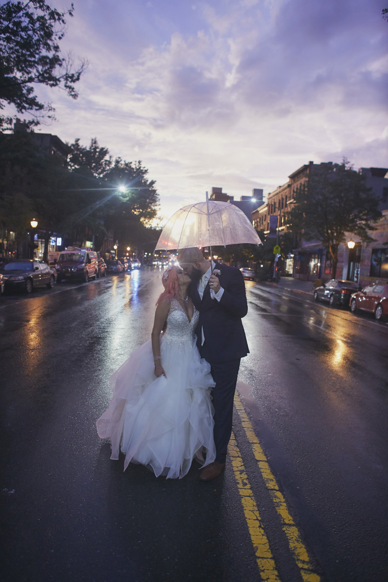bride and groom kissing on the rain