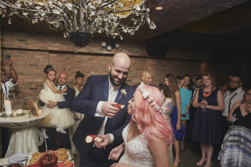 groom feeding bride with wedding cake