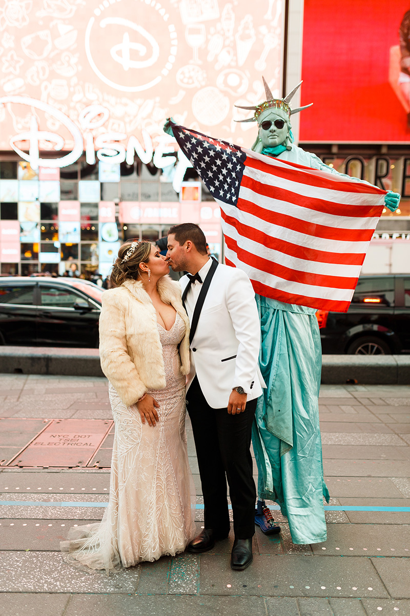 Bride and groom with times square statue of liberty