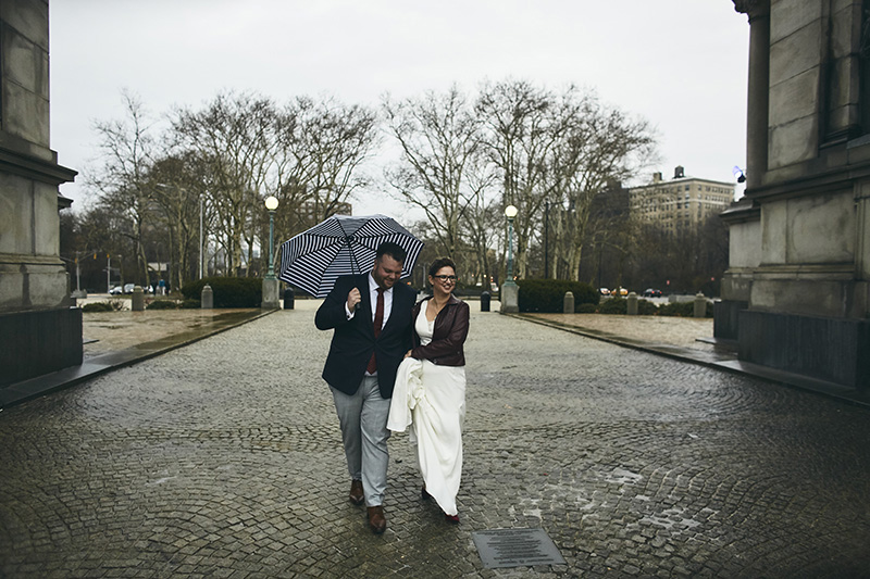 Bride and groom walking on  the rainy day  in NYC