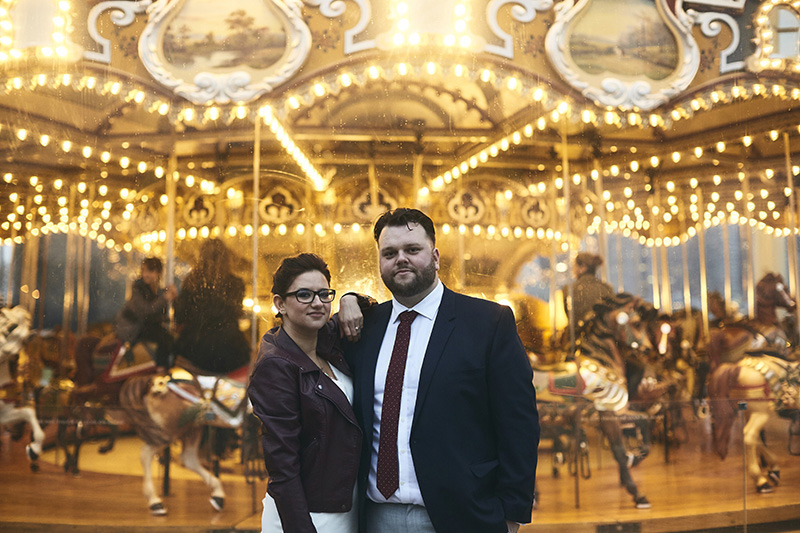 Bride and groom posing by the NYC carousel