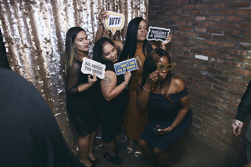 Guests posing at the wedding with photo booth props