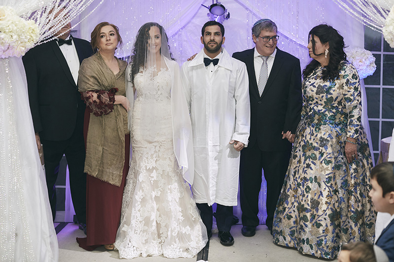 Orthodox Jewish bride and groom with parents