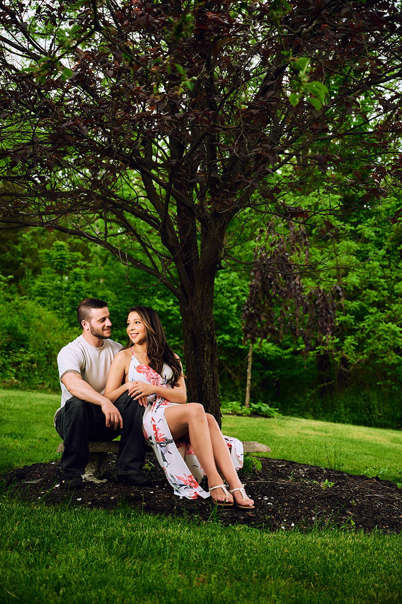 Couple sitting in front yard under the tree