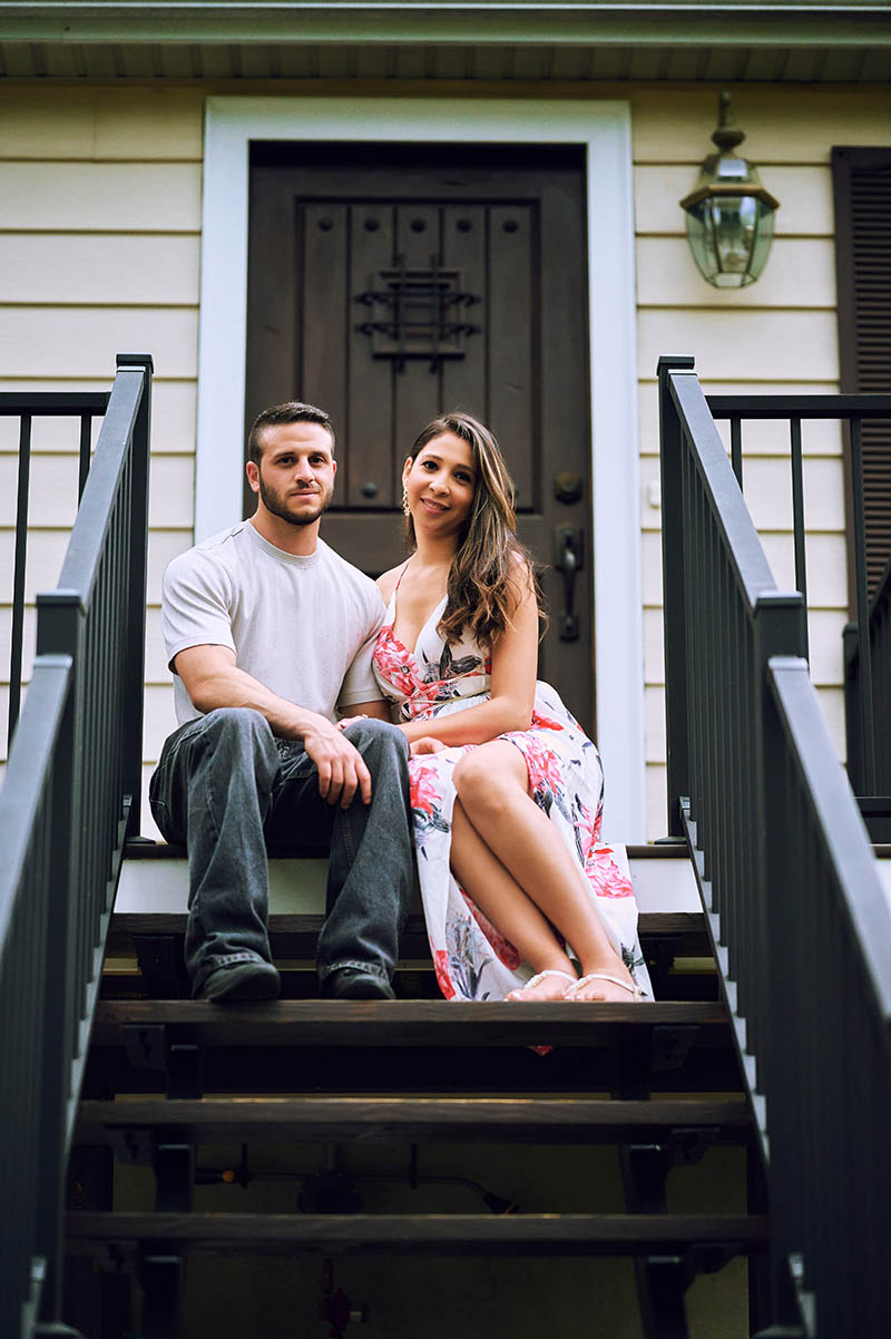 Couple sitting on staircase in front of their house