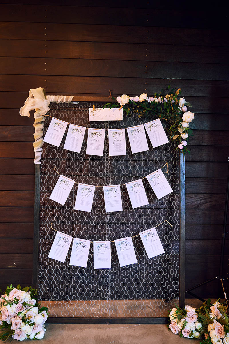 Wedding escort cards hanging on frame