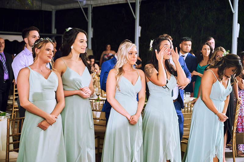 Bridesmaids watching first dance and crying