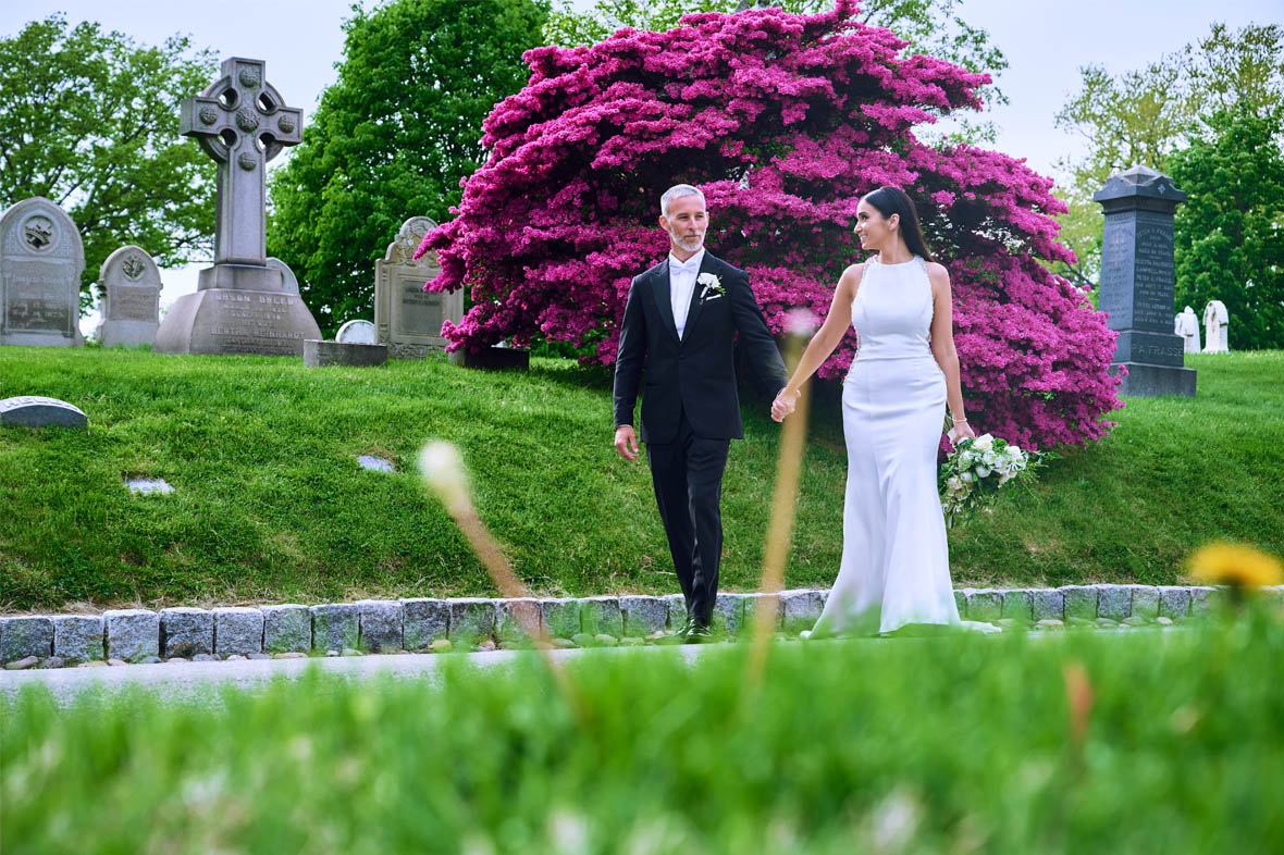 Wedding couple walking at the cemetery holding hands