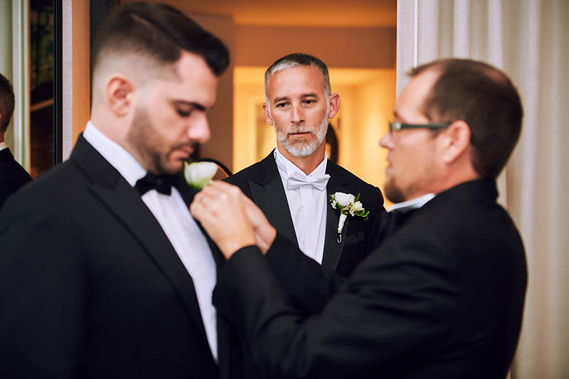 Groomsmen getting ready while groom looking in the background