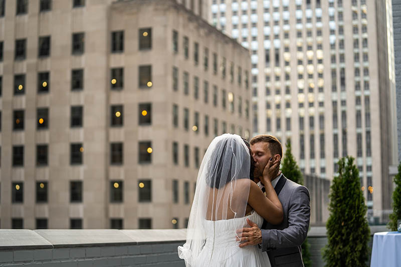 Bride kissing groom on rooftop