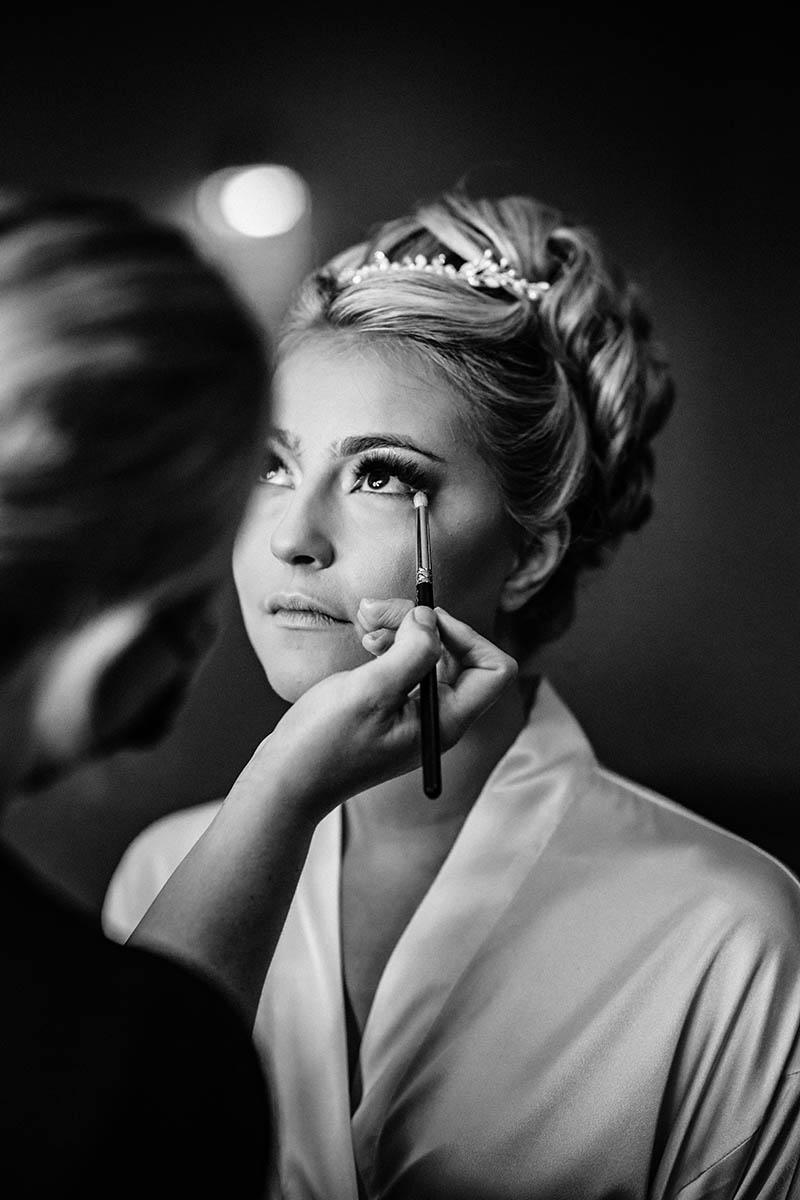 Bride putting the make up on
