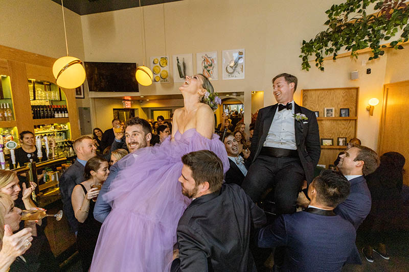 Bride and groom lifted on chairs