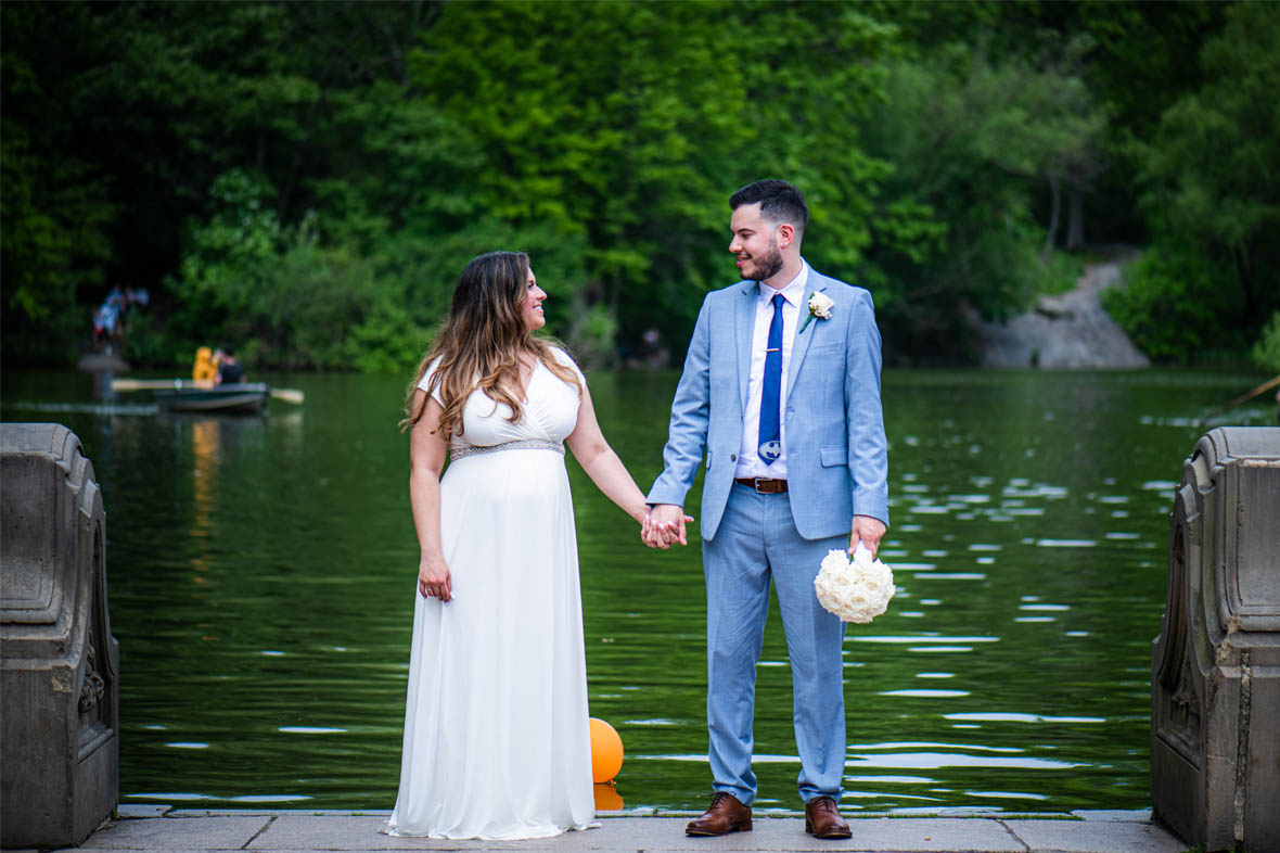 Bride and groom holding hands by the water
