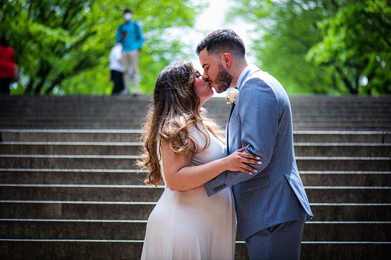 Bride and groom kissing on stairs in Bethesda Terrace