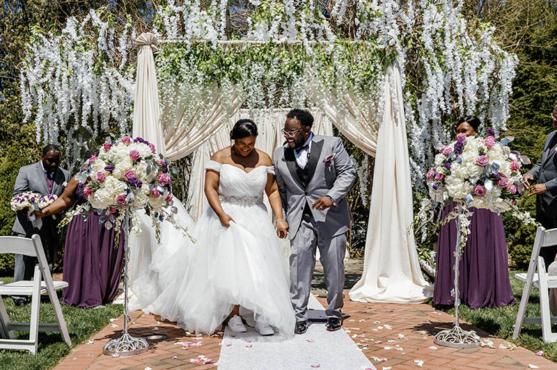 Bride and groom jumping over the broom
