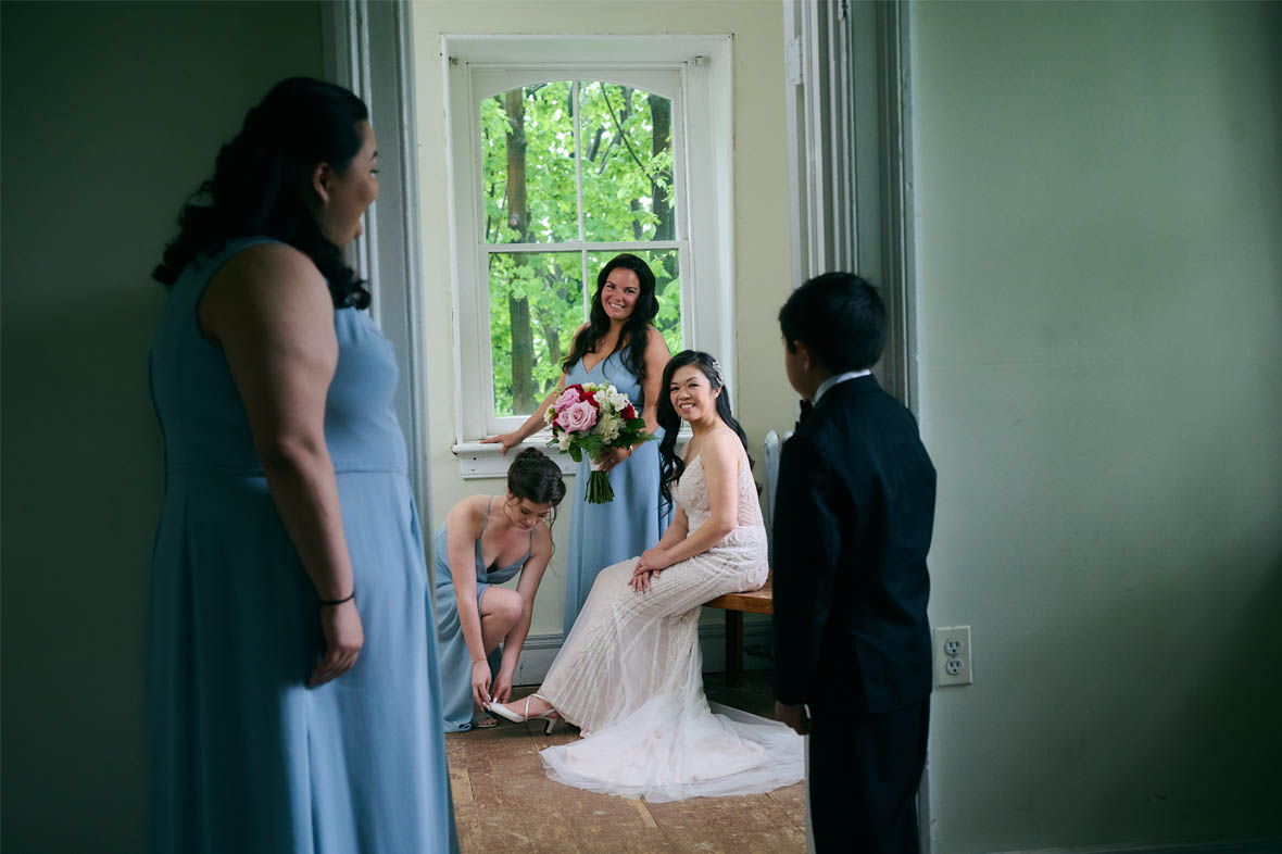 Bridesmaids helping bride put the shoes on