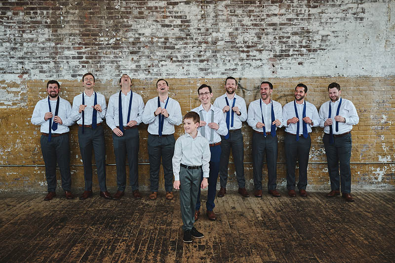 Groomsmen fixing their ties and laughing