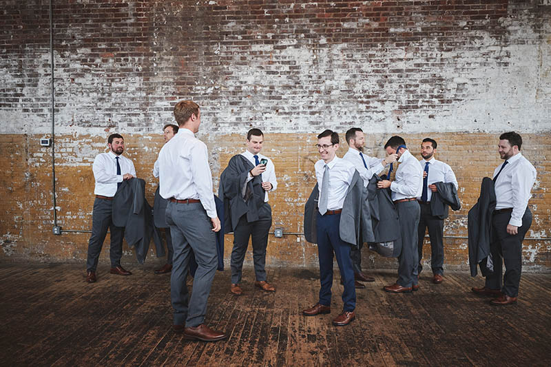 Groomsmen and groom putting the suits on