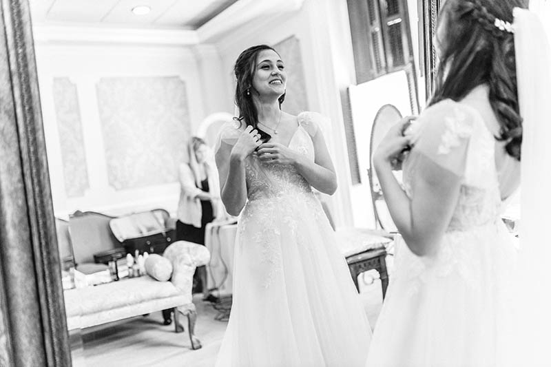 Bride looking at the mirror and fixing her hair
