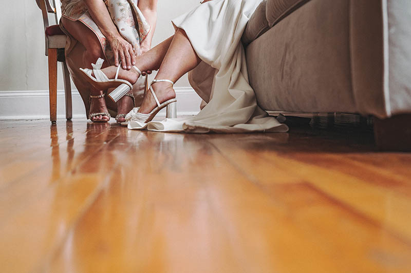 Bride putting the wedding shoes on