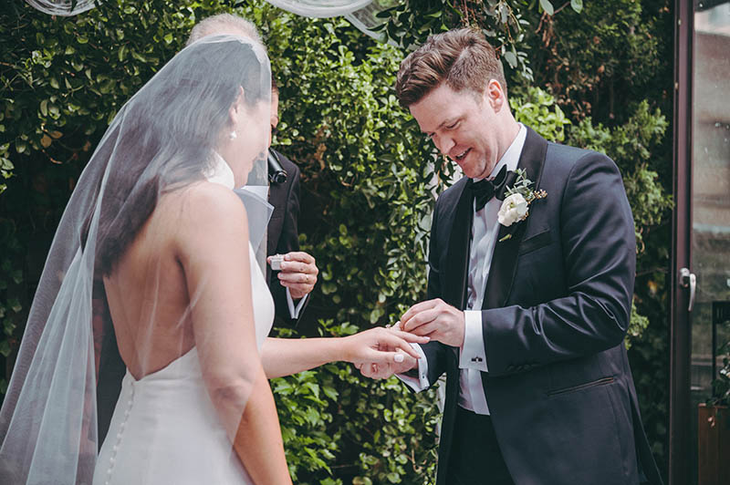 Groom putting the ring on brides finger