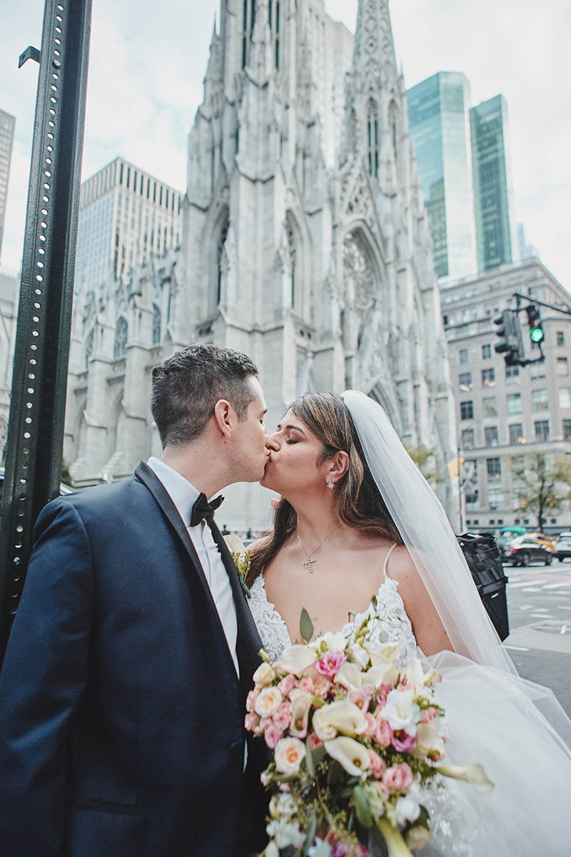 Bride and groom kissing in front of St. Patricks Cathedral