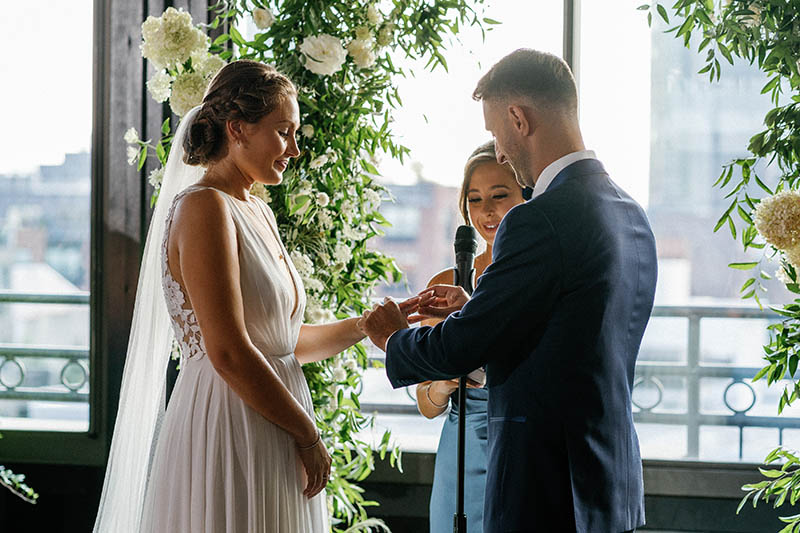 Groom putting the ring on brides finger