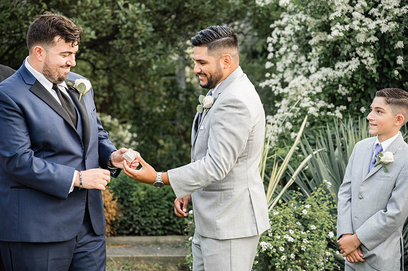 Best man handing rings to groom