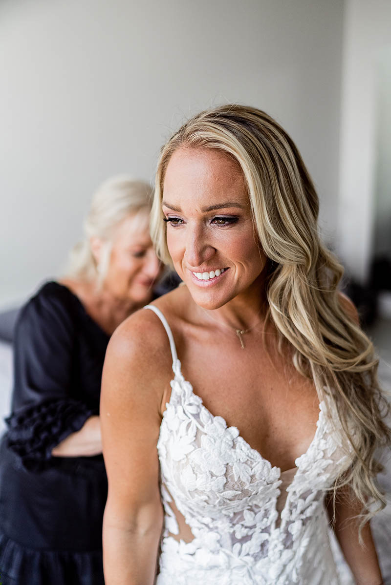 Mother helping bride put the dress on