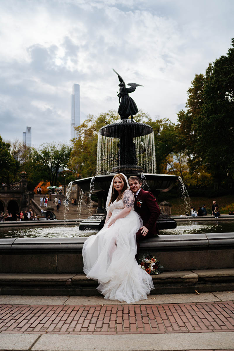 Bride and groom sitting on fountain