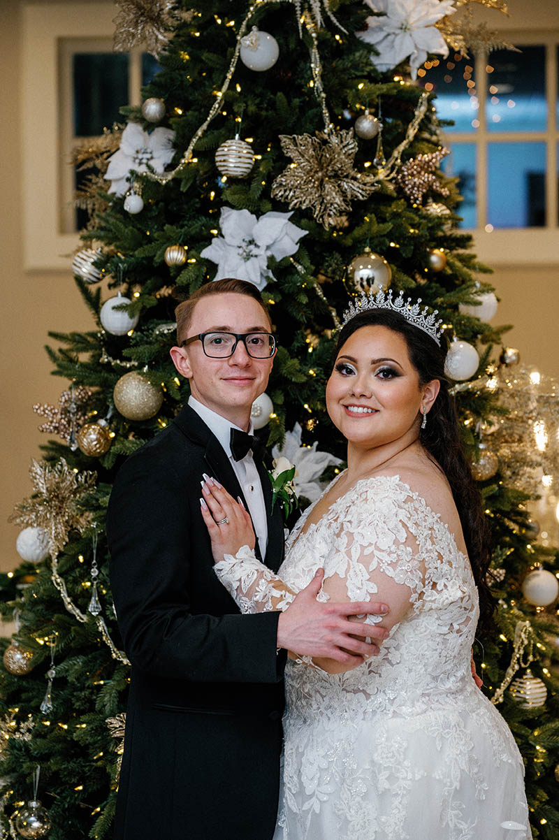 Bride and groom in front of Christmas tree