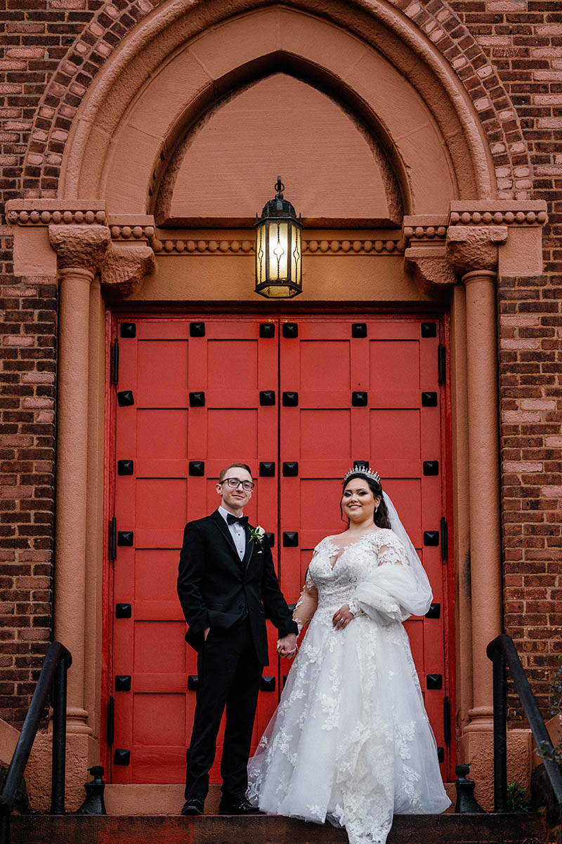 Bride and groom portrait in front of red church door