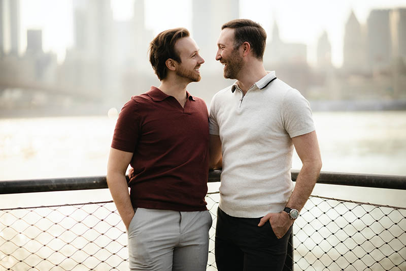 Gay couple looking at each other by the water