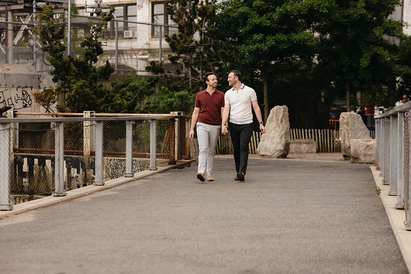 Gay couple holding hands and walking in park