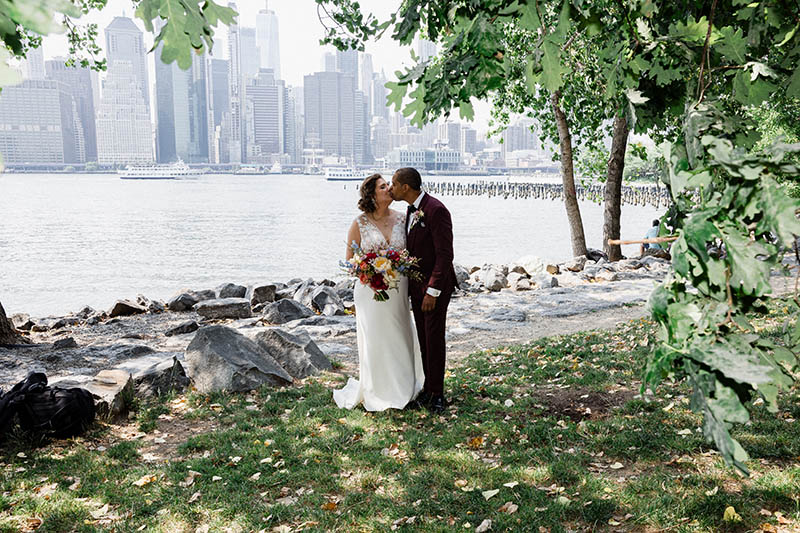 Bride and groom kissing in Brooklyn Bridge Park