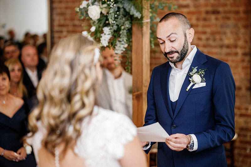 Groom reading personal wedding vows