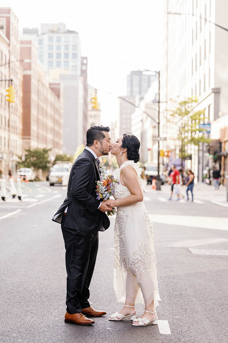 Bride and groom kissing on the street