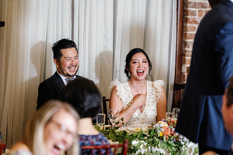 Bride and groom laughing to toast